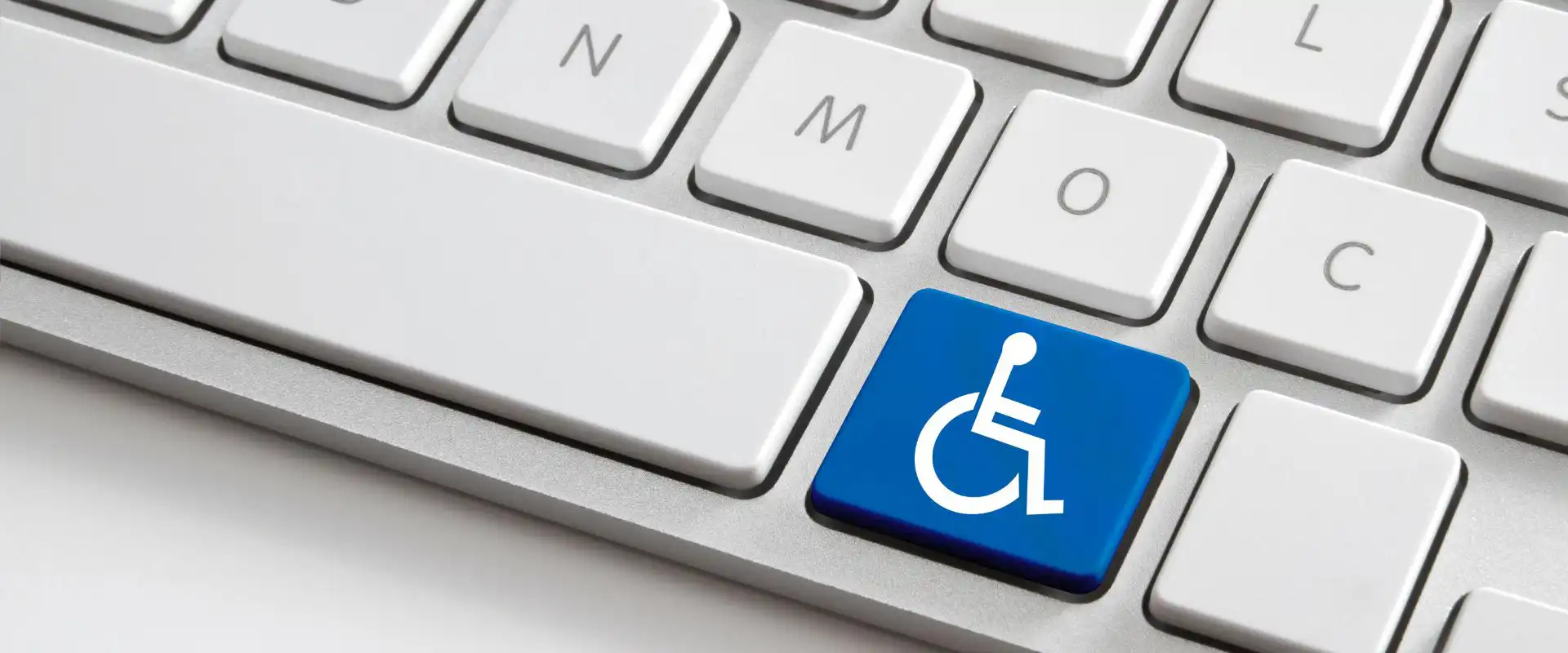 In the picture, a PC keyboard where one key has been replaced by the icon of a person in a wheelchair.